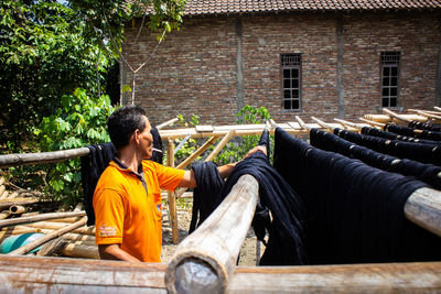  craftsmen do the dyeing process of the fabric lurik in tringsing village,  java, indonesia
