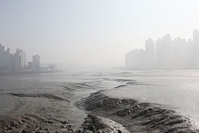 Scenic view of sea and buildings against clear sky