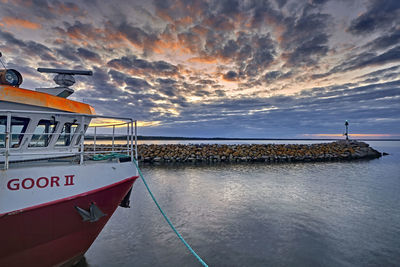 Ship moored on sea against sky during sunset