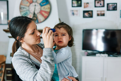 Brunette woman with child crying in her arms