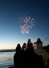 Low angle view of firework display against clear sky at night