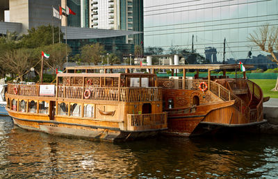 Boats moored in canal by buildings in city