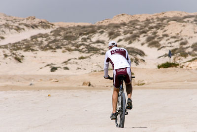 Rear view of man riding bicycle