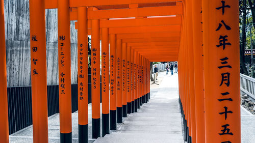 Wooden posts in building against orange sky