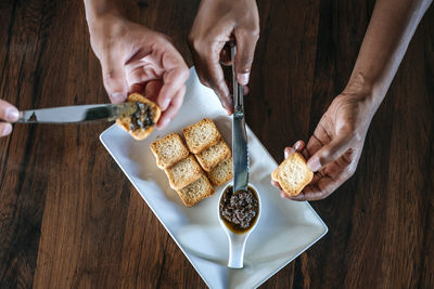 Close-up of a couple eating olive pate with bread in restaurant