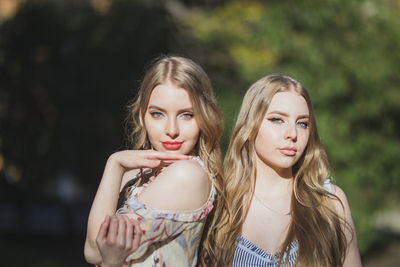 Portrait of beautiful friends standing in park