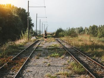 Railroad track amidst plants against sky