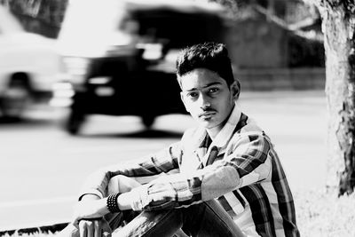 Portrait of teenager sitting on roadside