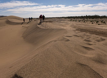 People walking on sand dune in desert