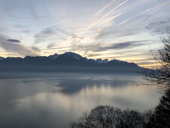 Scenic view of lake and mountains against sky during sunset