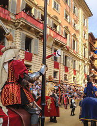 People on street against buildings in city