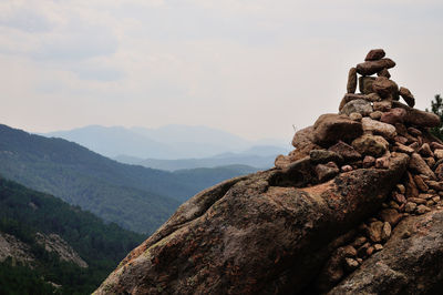 Man standing on rock against sky