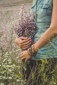 Lady with wind flowers bouquet in field scenic photography