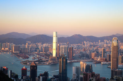 Aerial view of buildings in city at sunset