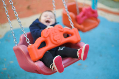 Close-up of boy on swing at playground