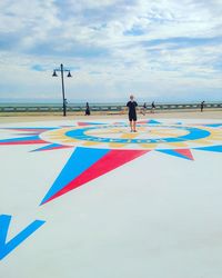 People on promenade against sky