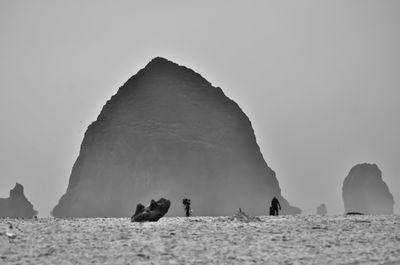 Panoramic view of rocks on shore against clear sky