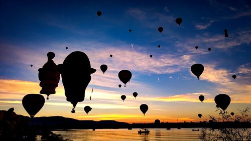 Low angle view of hot air balloons against sky during sunset