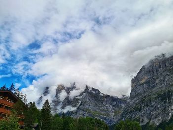 Low angle view of buildings and mountains against sky