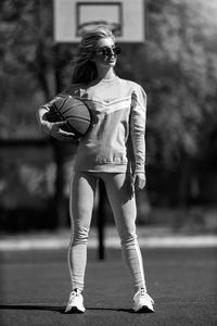 Full length portrait of young woman standing outdoors