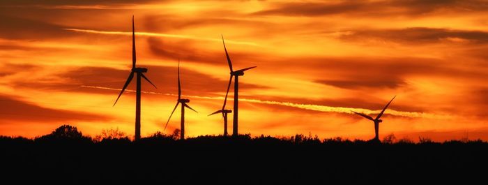 Silhouette of wind turbines at sunset