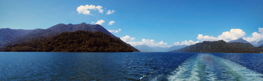 Panoramic view of lake and mountains against blue sky