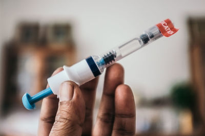 Close-up of human hand holding syringe