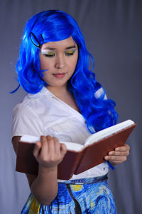 Portrait of young woman holding book