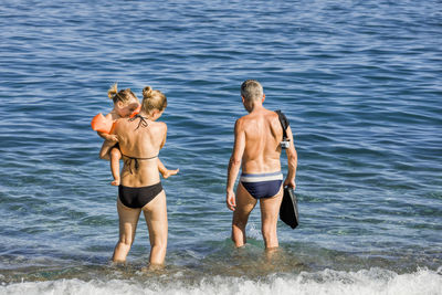 Family in sea on sunny day