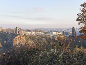 View of bridge in city against cloudy sky