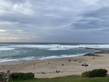Group of people on beach against sky