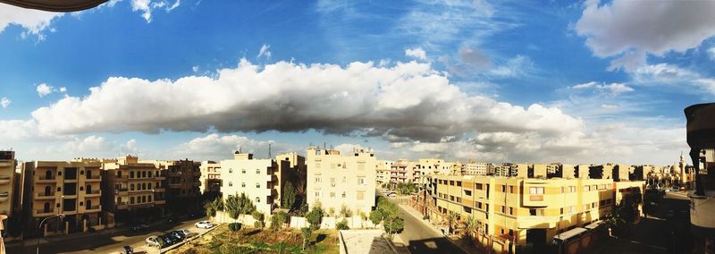 Panoramic view of cityscape against cloudy sky