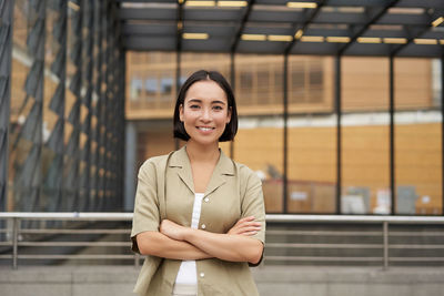 Portrait of young woman standing in city