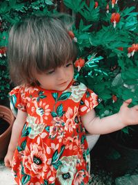 Cute girl looking at plants in the garden 
