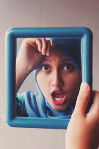 Close-up of young woman reflection in mirror