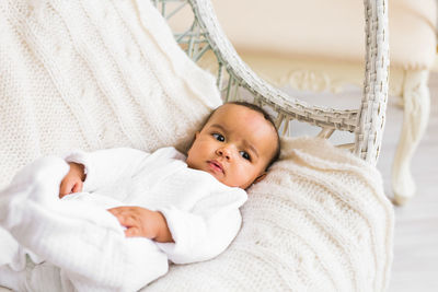 Portrait of cute baby lying on bed