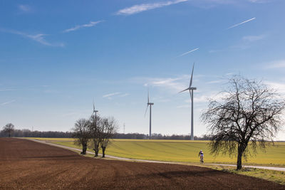 Scenic view of field with windturbines against sky