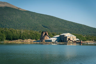 Scenic view of lake by buildings against sky