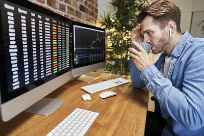 Side view of young man working at office