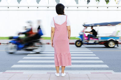 Rear view of woman walking on street in city