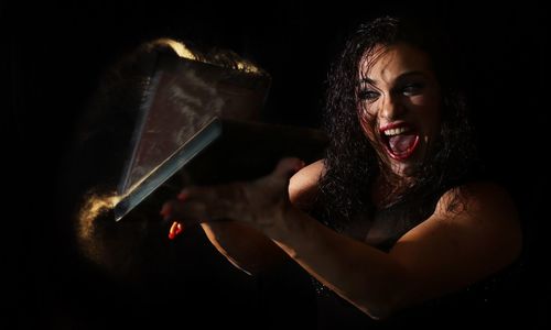 Woman dusting containers while shouting in darkroom