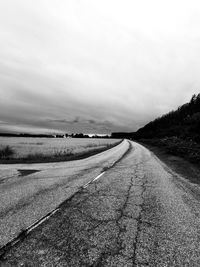 Empty road along landscape against sky