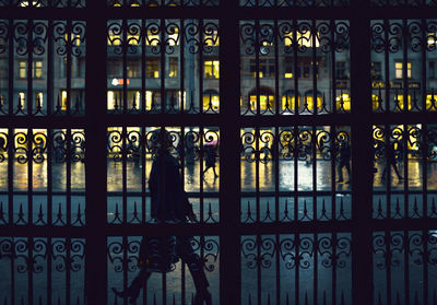 Woman seen through closed gate