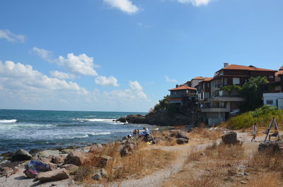 Scenic view of beach and buildings against sky
