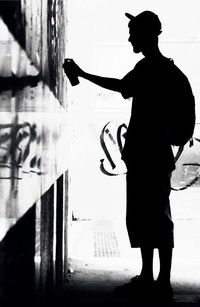 Silhouette man with arms raised standing in city