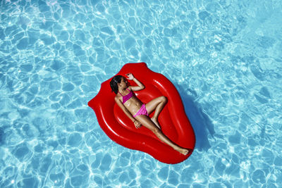 Little girl floating on a air mattress in a pool