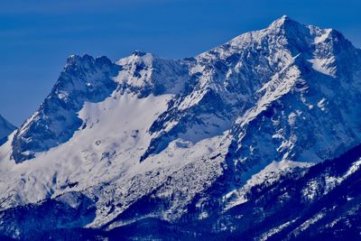 Scenic view of snowcapped mountains against blue sky