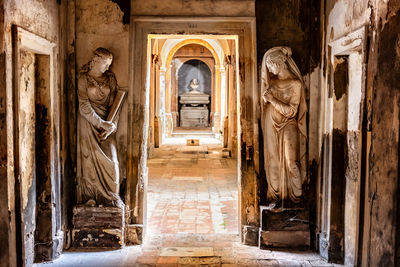 Cemetery corridor background with two statues .