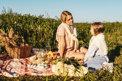 Rear view of women sitting on plants