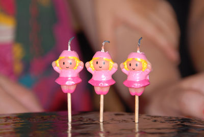 Close-up of pink birthday candles on cake